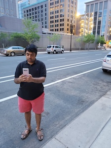 A man standing and doing measurement on the street